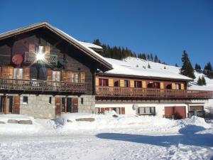 ein großes Gebäude mit Schnee auf dem Boden davor in der Unterkunft Hotel-Restaurant le Relais Panoramique in Les Crosets