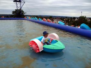 a young boy riding in a boat in the water at Villa La Vita in Hévíz