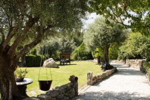 einen Garten mit einem Baum und einer Steinmauer in der Unterkunft Quinta Do Meira in Braga