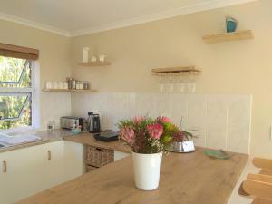 a kitchen with a vase of flowers on a wooden table at Spectrum of views near Muizenberg in Lakeside