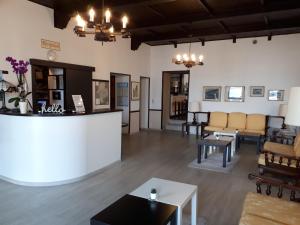 a living room with chairs and tables and a counter at Hotel Eden in Baveno