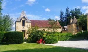 an old stone house with a red chair in the yard at Le Petit Manoir de Vitrac in Vitrac +30 photos