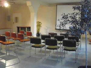 a room with a table and chairs and a screen at klassMo Gästehaus in Luckenwalde