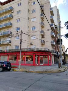 Un gran edificio con fachada roja en una calle. en Apartamento Agustín, en San Bernardo