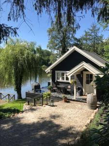 une petite maison à côté d'une masse d'eau dans l'établissement Sommerhus i idylliske omgivelser, à Veksø