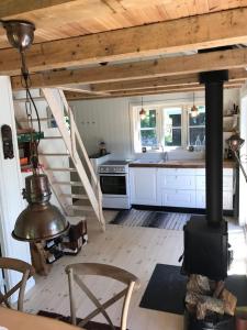 une cuisine avec cuisinière et un escalier dans une maison dans l'établissement Sommerhus i idylliske omgivelser, à Veksø