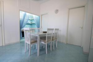 comedor con mesa blanca y sillas en Cielo Azzurro, en Torre Canne