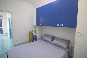 1 dormitorio con 1 cama y armarios azules en Cielo Azzurro, en Torre Canne