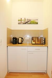 eine Küche mit Mikrowelle und Spüle in der Unterkunft Fewo Burgunder in Hanhofen