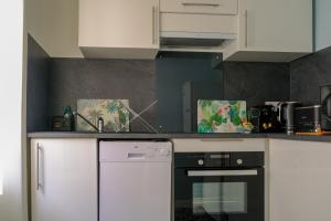 a kitchen with white cabinets and a black oven at Duplex de charme quartier Opéra Graslin in Nantes