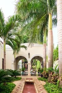 a courtyard with palm trees and a fountain at Casa Lecanda Boutique Hotel in Mérida