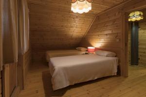 duas camas em um quarto com paredes de madeira em Luna Chalets da Montanha - Serra da Estrela na Covilh