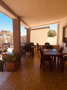 patio con mesas y sillas de madera y balcón en Villa Genny, en Altamura