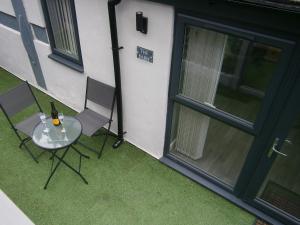 una mesa con dos sillas y una botella de vino en The Barn - Ilkeston - 1 Bedroom Flat, 2 Beds, Close to M1-A52 Long Eaton - Nottingham - Derby - Derbyshire - 400Mbs WiFi Free Parking!, en Ilkeston
