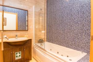 a bathroom with a tub and a sink and a bath tub at HouseLuz in Armação de Pêra +14 photos