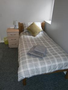 uma cama com um cobertor xadrez e um livro sobre ele em The Barn - Ilkeston- Close to M1-A52 Long Eaton - Nottingham - Derbyshire - 500Mbs WiFi! em Ilkeston