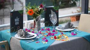 a table with a blue table cloth and a vase of flowers at THe NORDİC HOTEL in Kemer