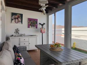 a living room with a table and a kitchen at Villa CarpeDiem Tarajalejo in Tarajalejo