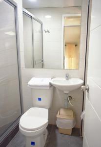 a bathroom with a toilet and a sink and a mirror at Finca Hotel La Molienda Quindiana in Montenegro