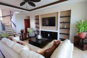 a living room with a white couch and a tv at Emerald Vista Villa in Vieux Fort