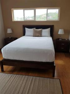 a bedroom with a large white bed with two night stands at Emerald Vista Villa in Vieux Fort