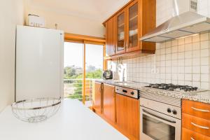 a kitchen with a stove and a white refrigerator at HouseLuz in Armação de Pêra