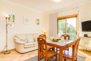 a living room with a table and a couch at HouseLuz in Armação de Pêra