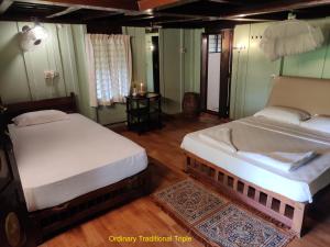 1 dormitorio con 2 camas y mesa. en Varkala Marine Palace, en Varkala