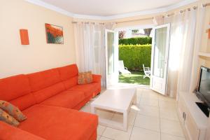 ein Wohnzimmer mit einem orangenen Sofa und einem TV in der Unterkunft Villa Gaudi in Oliva