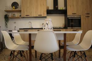una cucina con tavolo bianco e sedie bianche di Appartamento Il Mandorlo - Custonaci a Custonaci