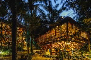una casa de bambú en la selva por la noche en Universo Pol Bamboo Hostel, en Morro de São Paulo