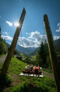 a group of people sitting on a swing at Haus Winkler in Vilpiano