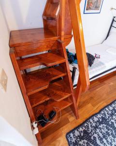 drewniana półka na książki obok łóżka piętrowego w obiekcie Eleonora Room & Breakfast w mieście Oristano