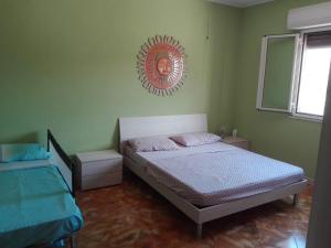 een slaapkamer met een bed en een foto aan de muur bij Villa Simone in Pachino