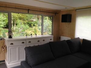 un soggiorno con divano e una grande finestra di Vakantiewoning De Kleine Duinberg - Chalet Nr 11 a Retie