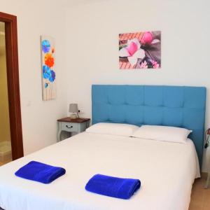 un letto con due cuscini blu sopra di Casa Mate Cotillo Mar a Cotillo