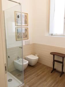 a bathroom with a toilet and a glass shower at DE PIANTE GUEST in Busto Arsizio