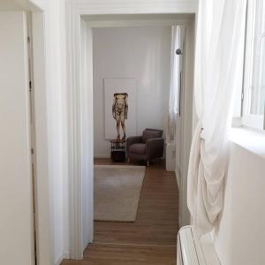 a hallway with a chair and a statue in a room at DE PIANTE GUEST in Busto Arsizio