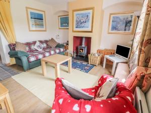 a living room with a red couch and a fireplace at Crinan Canal Cottage in Lochgilphead