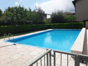 een zwembad met blauw water in een tuin bij garda felice in Desenzano del Garda