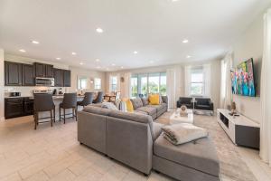 a large living room with a couch and a kitchen at Charming Home by Rentyl Near Disney with Private Pool, Game Room & Resort Amenities - 7489M in Orlando