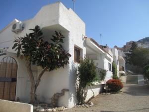 a white house with a tree in front of it at Bungalow CASIOPEA Internet 300 Mb SAT SMARTTV in El Campello
