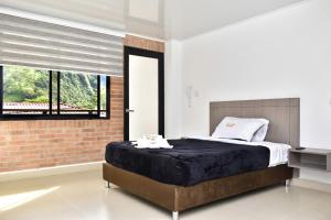 a bedroom with a bed and a brick wall at Hotel el peñón in Santa María
