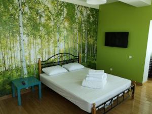 a bedroom with a bed with a mural of trees at The Place Astana Hostel in Astana