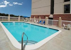 a swimming pool in front of a building at Comfort Suites University - Research Park in Charlotte