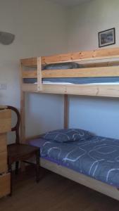 a bedroom with two bunk beds and a chair at Chez Ghislaine in Verdun-sur-Meuse