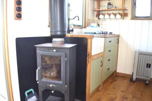 a kitchen with a wood stove in a kitchen at Rose Shepherds Hut in Badlesmere