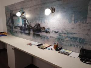 a desk with books on it with a wall with a picture of a pier at The Place Astana Hostel in Astana