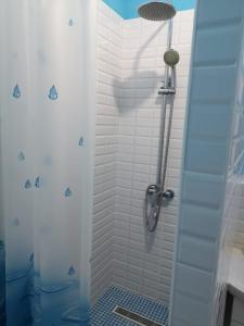 baño con ducha y puerta de cristal en The Place Astana Hostel, en Astana