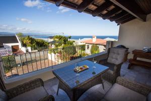 a balcony with a table with a view of the ocean at Mountain and Sea View Getaway in Plettenberg Bay